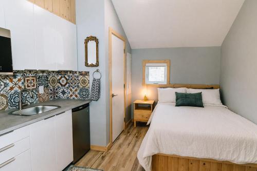 a small bedroom with a bed and a sink at Trailhead Tuck-inn in Nordegg