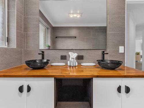 a bathroom with two sinks on a wooden counter at Ultimate Beachside Haven in Cabarita - Pet Friendly in Cabarita Beach
