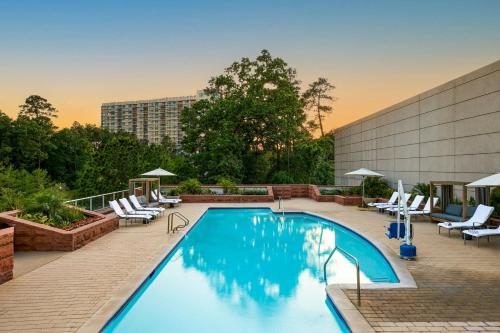 a swimming pool with lounge chairs and a building at The Woodlands Waterway Marriott Hotel and Convention Center in The Woodlands