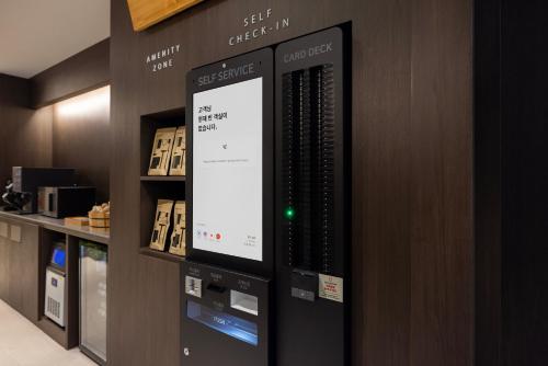 a computer screen on a wall in a store at Aank Ryokan Hotel Suwon in Suwon