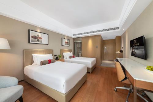 a hotel room with two beds and a desk at Chengdu Yueming Hotel,2-minute walk to Zhongba Subway ,close to Kuanzhai Alley and Chunxi Road,Free laundry, Free coffee, Chengdu food,English communication well,Private travel advice in Chengdu