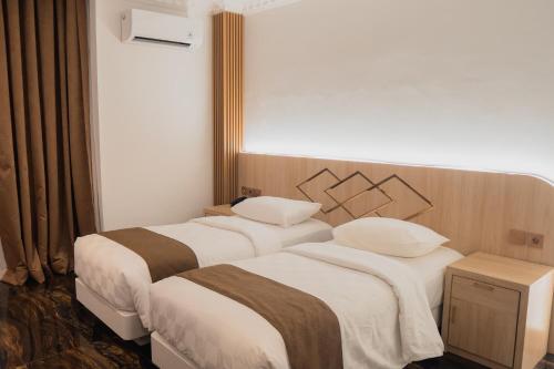Ένα ή περισσότερα κρεβάτια σε δωμάτιο στο Fahira Hotel Syariah Padang