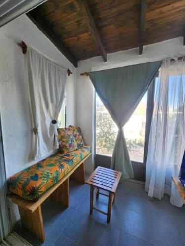 a room with a bench in a room with windows at Delfines in Las Grutas