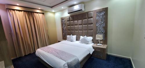 una stanza d'albergo con un letto e una televisione sul muro di شاليهات وشقق ليالي رهيف a Abha