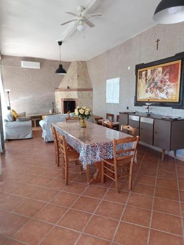 a living room with a table with chairs and a fireplace at PM 1 Via Ovidio Guest House in Leporano Marina