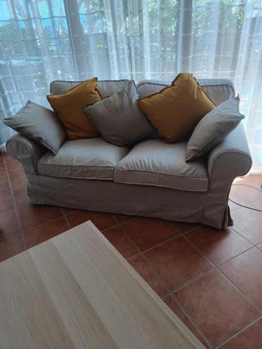 a couch with pillows on it in front of a window at PM 1 Via Ovidio Guest House in Leporano Marina