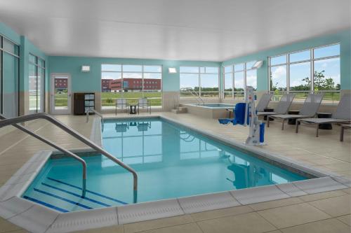 a large swimming pool with blue water in a building at SpringHill Suites by Marriott Grand Island in Grand Island