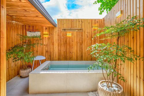 a hot tub in a wooden wall with two plants at Hta Tailored Service Home&fitness Near Seoul Stn in Seoul