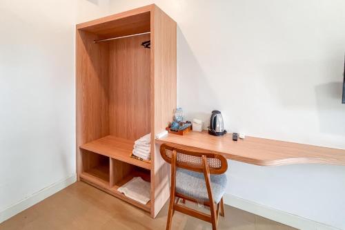 a wooden desk with a chair in a room at Urbanview Syariah Nawasena Guest House IKN in Sepaku