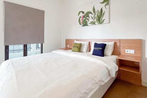 a bedroom with a large white bed with two pillows at Urbanview Syariah Nawasena Guest House IKN in Sepaku