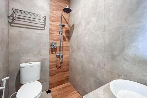 a bathroom with a shower and a toilet and a sink at Urbanview Syariah Nawasena Guest House IKN in Sepaku