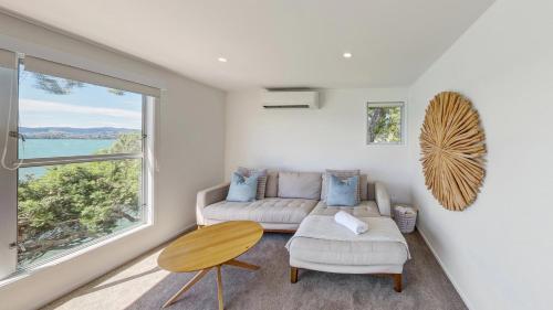 a living room with a couch and a table and a window at Harbour View Motel and Waterfront Apartments in Tauranga
