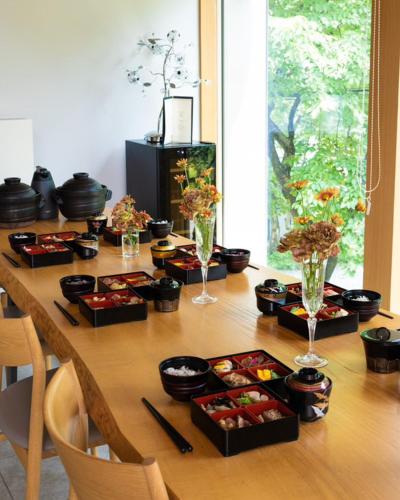 a wooden table with plates of food on it at Hakuba Jolie Maison by Jade Group in Hakuba