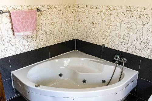 a white tub in a bathroom with a pink towel at Casa Naxxar 4 Floor Townhouse and Private Pool in Naxxar