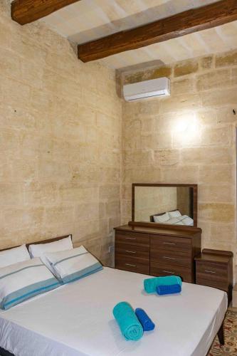 a bedroom with a white bed and a mirror at Casa Naxxar 4 Floor Townhouse and Private Pool in Naxxar