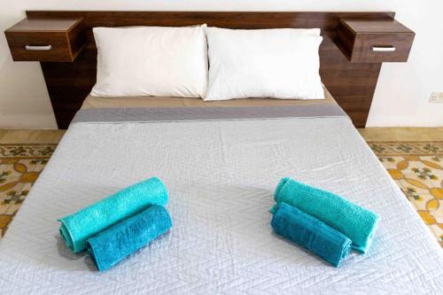 a bed with two blue pillows on it at Casa Naxxar 4 Floor Townhouse and Private Pool in Naxxar