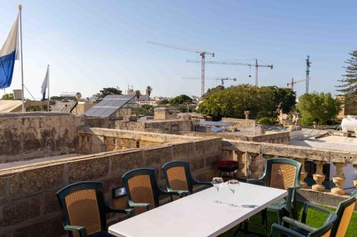 a table with wine glasses on top of a building at Casa Naxxar 4 Floor Townhouse and Private Pool in Naxxar