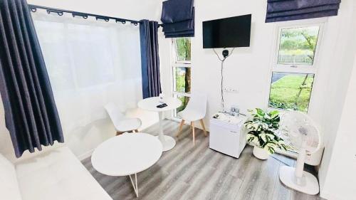 ein Wohnzimmer mit weißen Möbeln und einem Fenster in der Unterkunft The Snow Cottages in Pakha