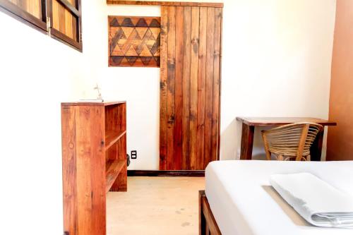 a bedroom with a bed and a wooden door at Maracuya Suites Zipolite in Zipolite