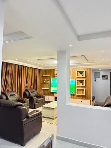 a living room with leather furniture and a television at newtown apartment olaleye iporin surulere nigeria in Iponri