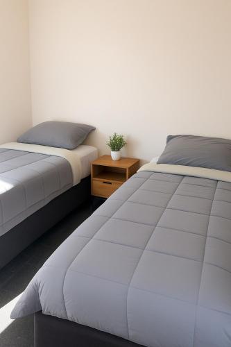 two beds sitting next to each other in a bedroom at La Maison in Rotorua