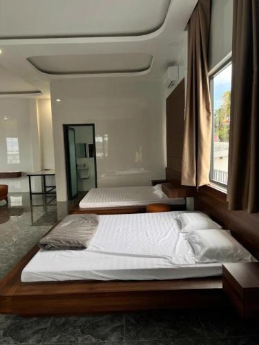 a bedroom with two beds and a large window at Happy House Gành Dầu in Phu Quoc