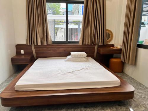 a large bed in a room with a window at Happy House Gành Dầu in Phu Quoc
