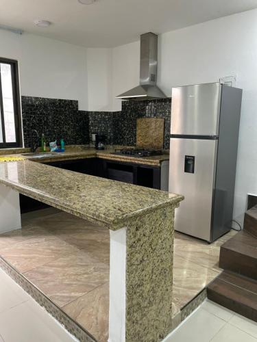 a kitchen with a granite counter top and a refrigerator at Alojamiento Centrico Facturamos in Villahermosa