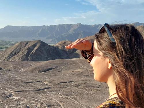 a woman standing on top of a mountain at JUMANA in Nazca