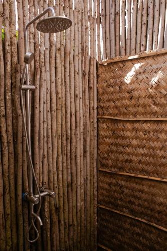 a bamboo wall with a shower in a room at Tổ Boutique Garden in La Gi