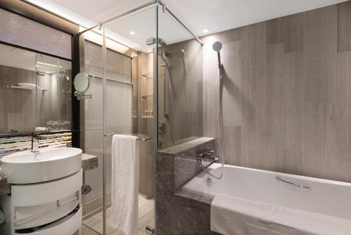 a bathroom with a sink and a bath tub at The Landis Taipei in Taipei
