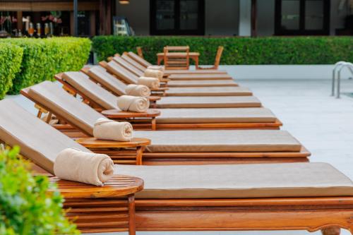 a row of wooden benches sitting on a patio at Rimping Village in Chiang Mai