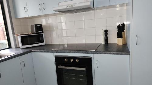 a kitchen with white cabinets and a black oven at The Goose Ponds in North Mackay