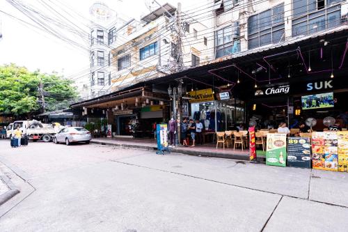 a street corner of a city with a store at The Hidden Khaosan - เดอะ ฮิดเด้นข้าวสาร in Bang Bua Thong Railway Station