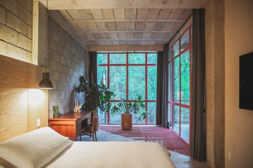 a bedroom with a bed and a desk and a window at Xolo Condesa in Mexico City