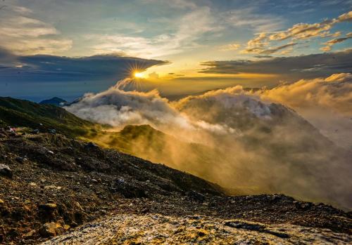 einen Blick auf einen Berg mit Wolken im Himmel in der Unterkunft Losmen Sibayak Berastagi in Berastagi