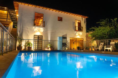 a swimming pool in front of a house at night at TERRAKOTA Heritage House in Mariquita