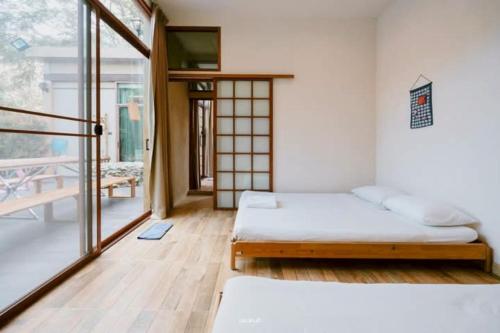 a bedroom with two beds and a balcony at The X10 Nordic Tent and Glamping Pool Villa Khaoyai เขาใหญ่ - SHA Certified in Ban Thung Sawang