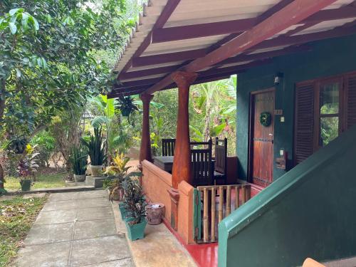 a front porch of a house with a green and red at Jaana Guest in Sigiriya
