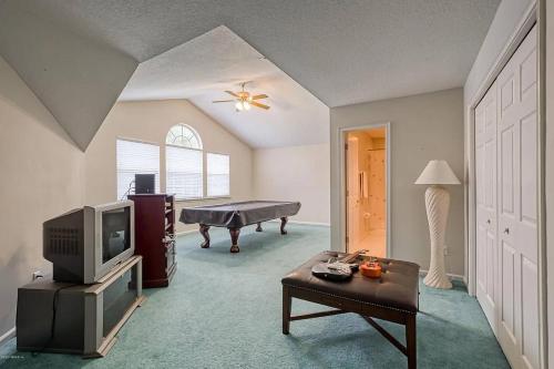 a living room with a tv and a pool table at Beyond the Gate in Bay Tree in Pine Bluff