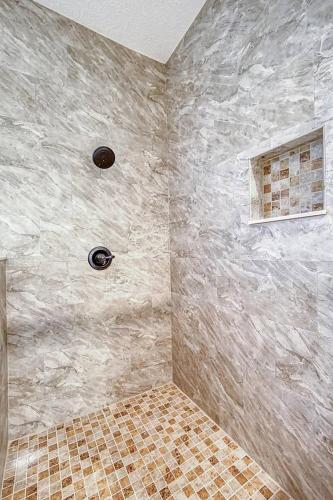 a bathroom with a shower with a stone wall at Beyond the Gate in Bay Tree in Pine Bluff