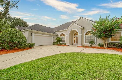 a large house with a garage and a driveway at Beyond the Gate in Bay Tree in Pine Bluff