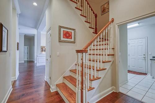 a staircase in a home with white walls and wood floors at Beyond the Gate in Bay Tree in Pine Bluff