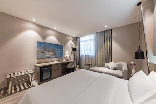Ένα ή περισσότερα κρεβάτια σε δωμάτιο στο Urbain S Hotel SM Plaza Xiamen Gaoqi Airport Branch