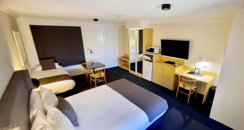 a hotel room with two beds and a television at Hotel Forster in Forster