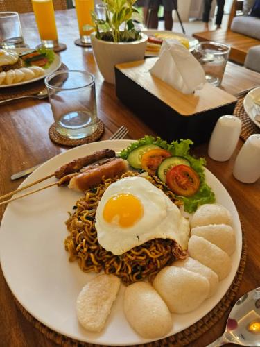 un plato de comida con un huevo encima de los fideos en Emilia 1 Bedroom Apartment Seminyak by Nagisa Bali, en Kerobokan