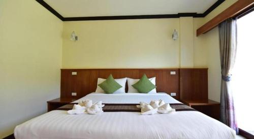 a bedroom with a large white bed with white flowers on it at The Green Hotel in Ko Lipe