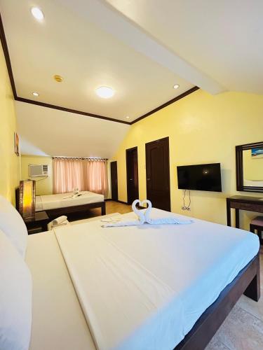 a large white bed in a room with a roomswersswersswersswersswersswers at Sheridan Villas Boracay in Boracay
