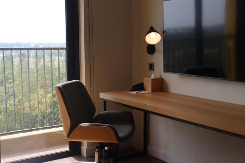 a office with a desk and a chair and a window at HIIVE by fusion Binh Duong - VSIP 1 in Thuan An