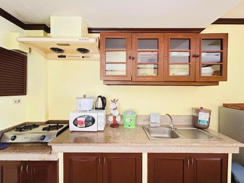 a kitchen with a sink and a microwave at Sheridan Villas Boracay in Boracay